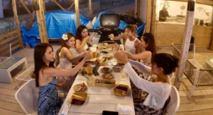 宮古島の海の家で女子旅グループがBBQとドリンクを楽しむ様子