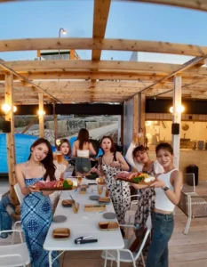 宮古島の海の家で女子旅グループがBBQとドリンクを楽しむ様子