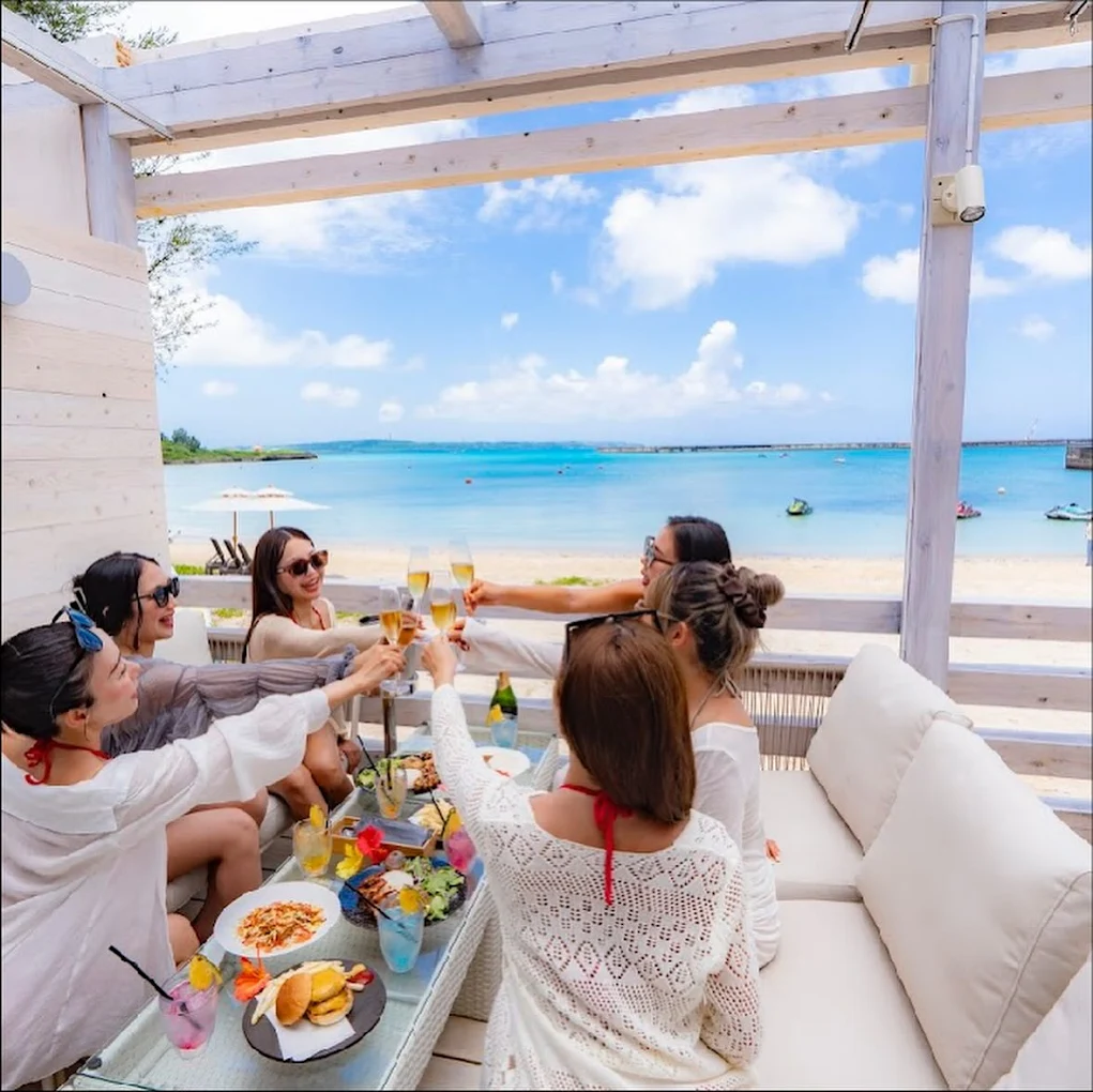 宮古島の海の家で女子旅グループがBBQとドリンクを楽しむ様子